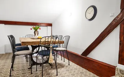 Jadalnia w stylu boho z drewnianym stołem i niebieskimi krzesłami