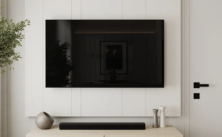 Nowoczesny salon z szarymi ścianami, białym telewizorem i minimalistycznymi akcentami.