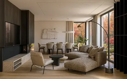 Wnętrze salonu z brązową sofą, jadalnią i nowoczesnymi akcentami.