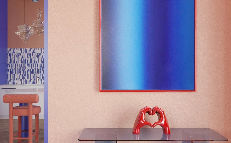 Wnętrze z różową ścianą, niebieską grafiką i czerwonym akcentem w stylu dopamine decor.