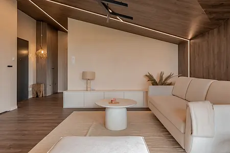 Wnętrze salonu w stylu boho i japandi z beżową sofą.