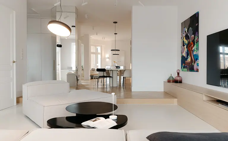Wnętrze w stylu eklektycznym z minimalistycznymi meblami i nowoczesnym oświetleniem.