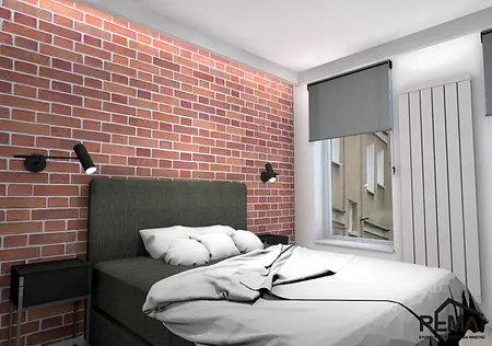 Wnętrze sypialni z ceglaną ścianą, szarym łóżkiem i minimalistycznymi lampami. Styl industrialny.