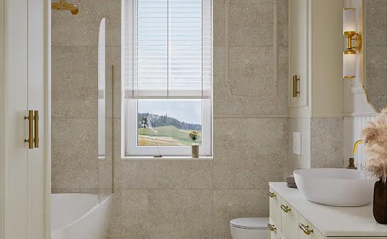 Wnętrze łazienki w stylu art deco i eklektycznym z wanną i eleganckimi akcentami.