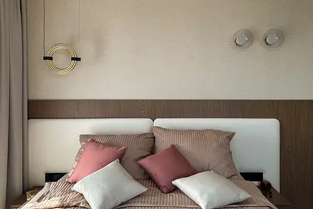 Wnętrze sypialni z brązowym łóżkiem, poduszkami i nowoczesnym oświetleniem.