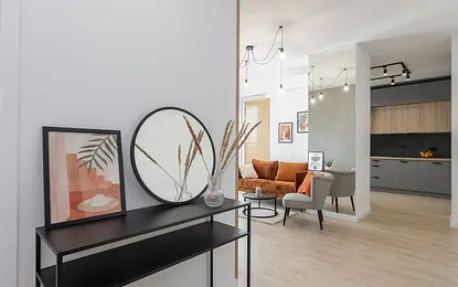 Wnętrze mieszkania w stylu industrialnym i minimalistycznym z pomarańczową sofą.