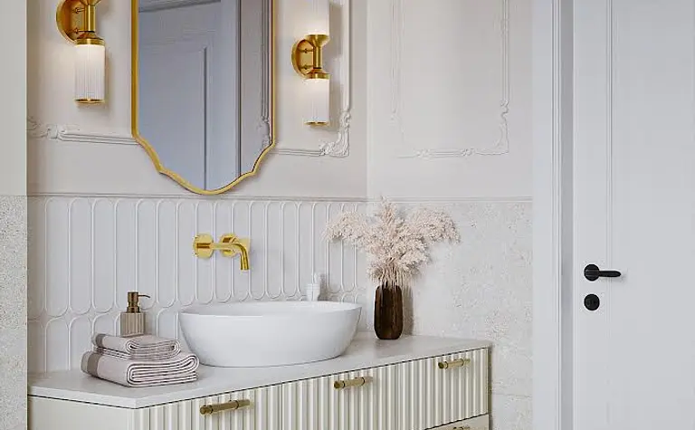 Nowoczesna łazienka w stylu art deco i eklektycznym z białą umywalką i złotymi detalami.