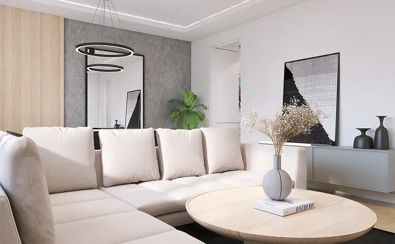 Nowoczesny salon z beżową sofą, okrągłym stołem i rośliną.