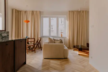 Wnętrze salonu w stylu quiet luxury, soft minimalizm i vintage z beżową sofą i drewnianymi akcentami.