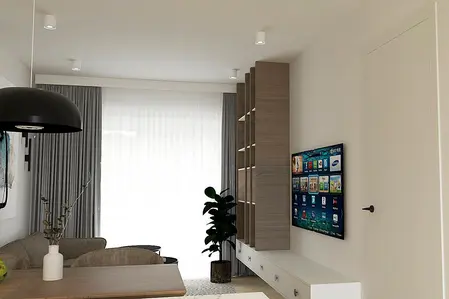 Wnętrze salonu z jasnymi ścianami, drewnianymi meblami i nowoczesnym oświetleniem.