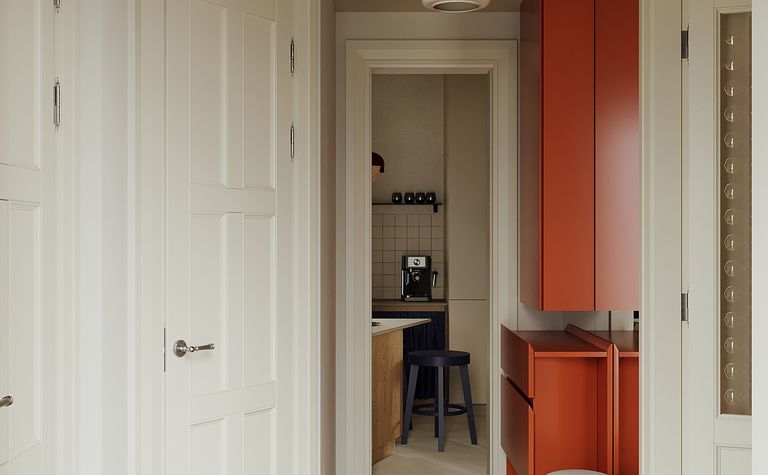 Przedpokój z tradycyjnymi i soft minimalizm meblami w odcieniach bieli i pomarańczy.