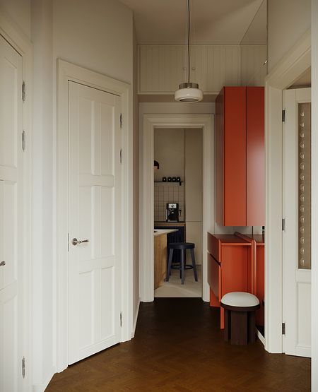 Przedpokój z tradycyjnymi i soft minimalizm meblami w odcieniach bieli i pomarańczy.