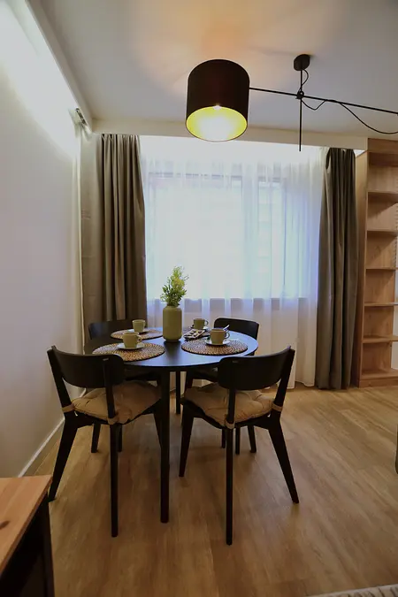 Wnętrze jadalni z minimalistycznym designem, nowoczesnym stołem i skandynawskimi dodatkami.