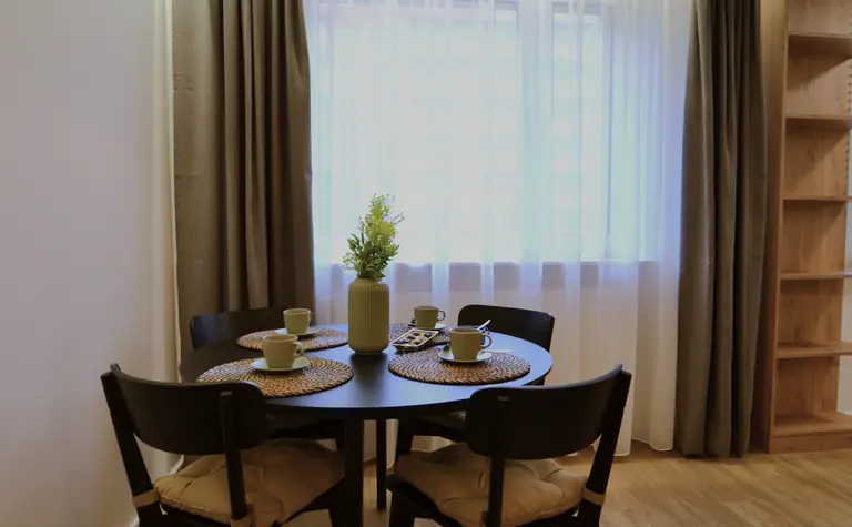 Wnętrze jadalni z minimalistycznym designem, nowoczesnym stołem i skandynawskimi dodatkami.
