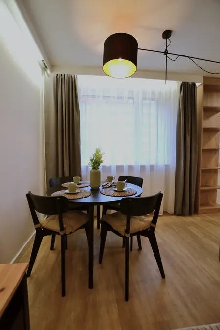 Wnętrze jadalni z minimalistycznym designem, nowoczesnym stołem i skandynawskimi dodatkami.