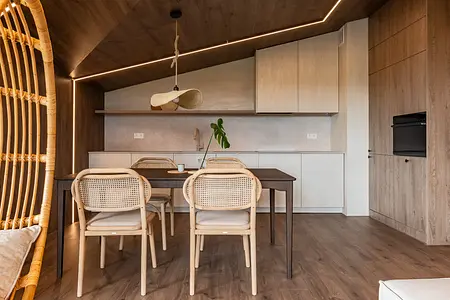 Wnętrze jadalni w stylu boho i skandynawskim z drewnianym stołem i naturalnymi akcentami.