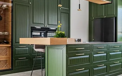 Kuchnia eklektyczna z zielonymi meblami i drewnianym blatem, roślinami w doniczkach.