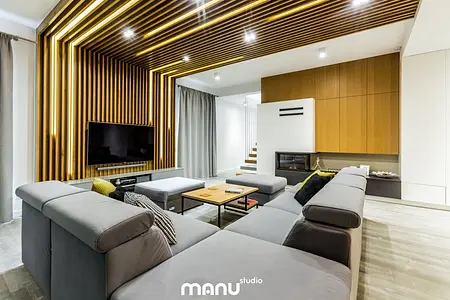 Wnętrze salonu w stylu industrialnym z drewnianą ścianą i minimalistycznym umeblowaniem.