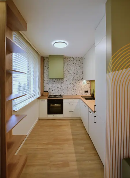 Kuchnia w stylu minimalistycznym i skandynawskim z białymi meblami, drewnianymi detalami i nowoczesnym oświetleniem.