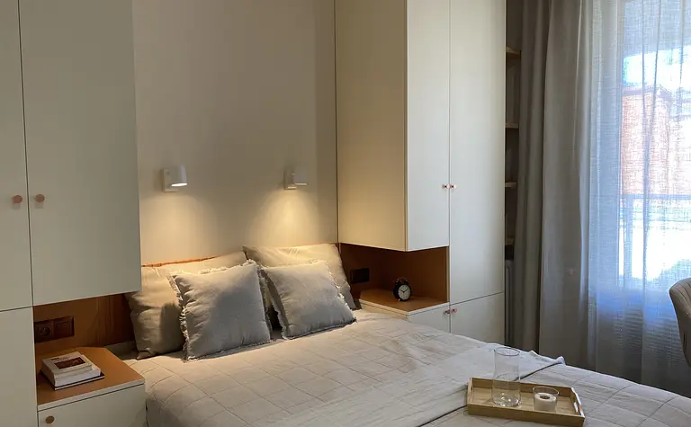 Sypialnia w stylu japandi z minimalistycznymi meblami i skandynawskim oświetleniem.