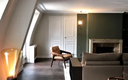 Wnętrze eklektycznego salonu z brązową sofą i nowoczesnymi akcentami.