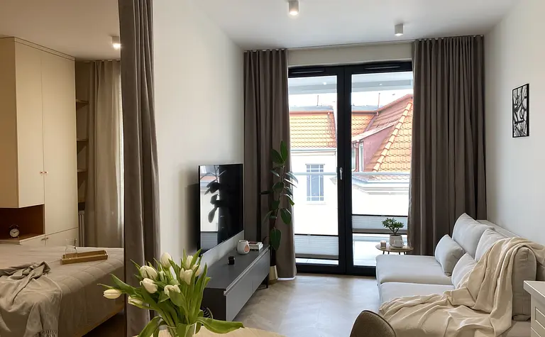 Wnętrze salonu w stylu japandi, minimalistycznym i skandynawskim z dużymi oknami.