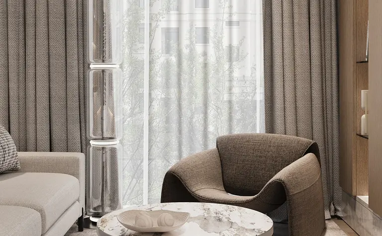 Wnętrze salonu w stylu minimaluxe z brązowym fotelem, szarymi zasłonami i nowoczesnym stolikiem.