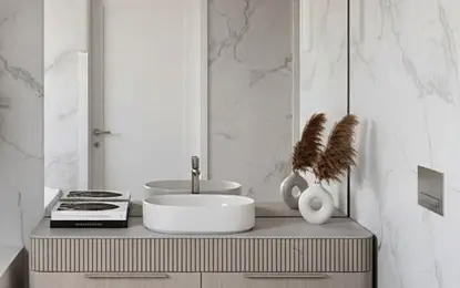 Nowoczesna łazienka z białą umywalką, drewnianymi szafkami i marmurowymi ścianami, minimalistyczny styl