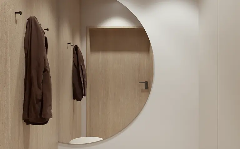 Przedpokój z elementami boho i minimalistycznymi, okrągłe lustro i drewniane akcenty.