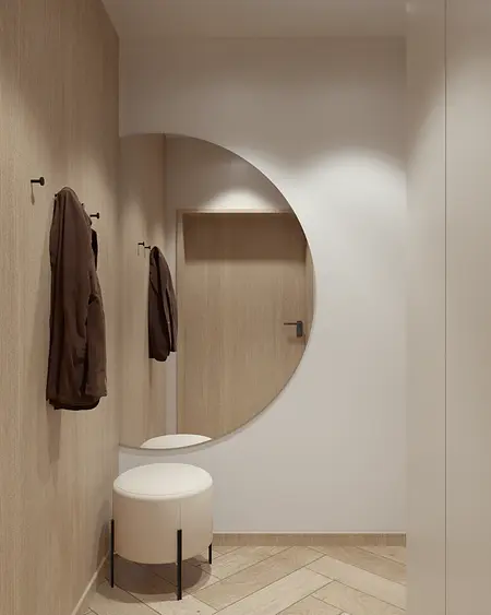 Przedpokój z elementami boho i minimalistycznymi, okrągłe lustro i drewniane akcenty.