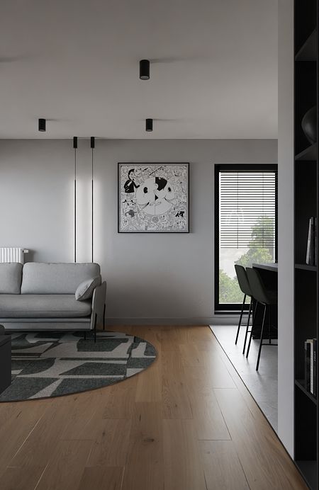 Wnętrze minimalistycznego salonu z szarymi ścianami, szarym sofą i drewnianą podłogą.