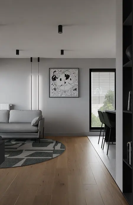 Wnętrze minimalistycznego salonu z szarymi ścianami, szarym sofą i drewnianą podłogą.