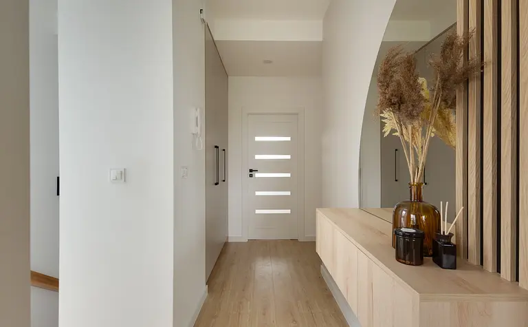 Przedpokój w stylu japandi z drewnianymi detalami i minimalistycznym wystrojem.