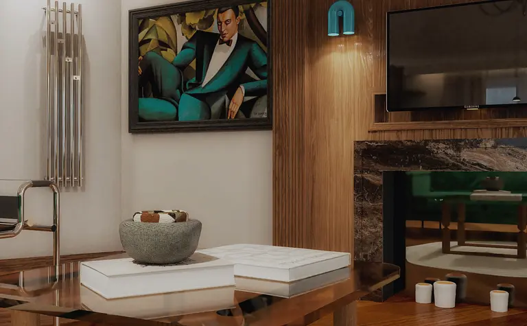 Wnętrze salonu w stylu art deco z zieloną sofą i drewnianymi detalami.