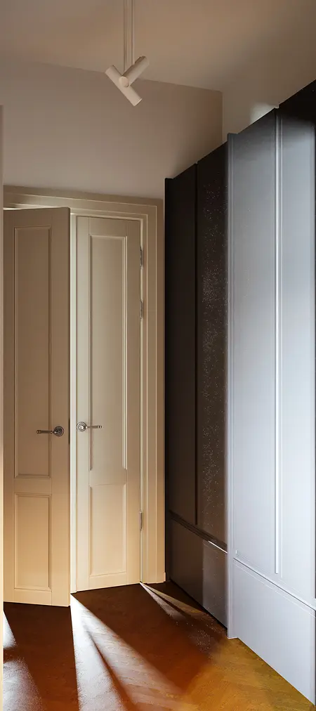 Garderoba w stylu soft minimalizm z tradycyjnymi elementami, beżowe drzwi i szafa.