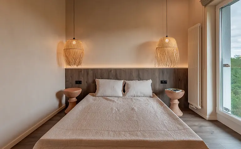 Sypialnia z łóżkiem, drewnianymi akcentami i lampami w stylu boho