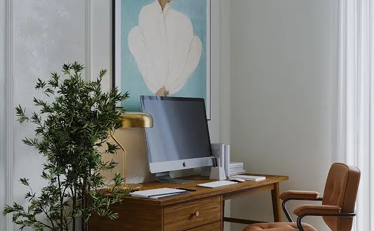 Wnętrze gabinetu w stylu art deco i eklektycznym z biurkiem i rośliną.