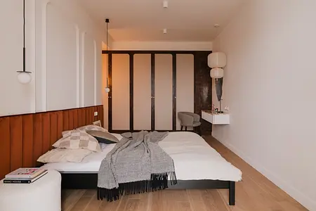 Sypialnia z brązowym łóżkiem, nowoczesnymi lampami i drewnianymi detalami, styl art deco, vintage, eklektyczny.