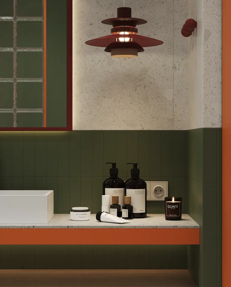 Wnętrze łazienki w stylu art deco z zielonymi i pomarańczowymi detalami.
