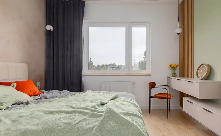Sypialnia w stylu japandi z zielonymi akcentami i minimalistycznym wystrojem.