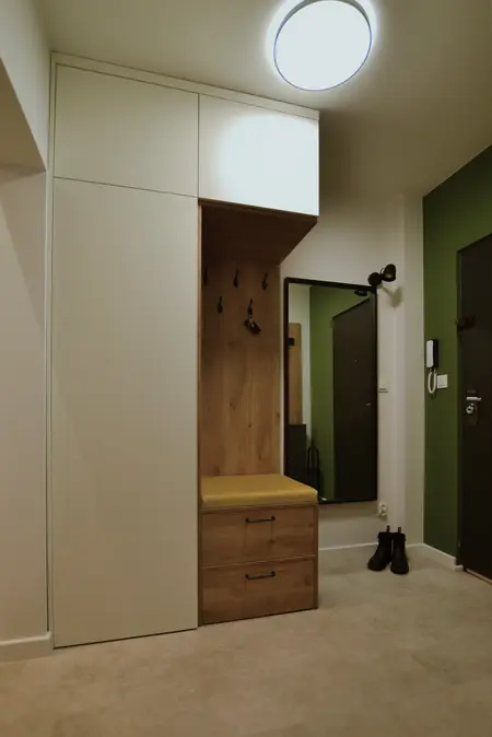 Przedpokój z minimalistycznym i skandynawskim designem, białe meble, drewniane elementy.