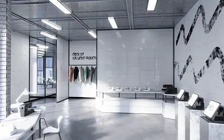 Wnętrze biura z minimalistycznym designem, białymi meblami i nowoczesnym oświetleniem.