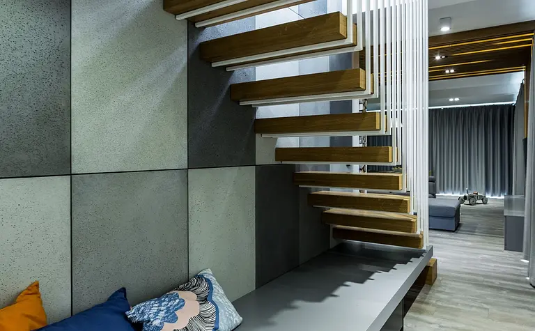 Wnętrze z drewnianymi schodami i poduszkami w stylu industrialnym, minimalistycznym i skandynawskim.