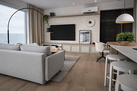 Wnętrze salonu w stylu japandi i minimalistycznym z szarymi meblami.