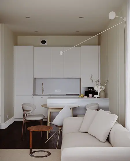 Nowoczesna kuchnia w stylu soft minimalizm z białymi meblami i drewnianym stołem.