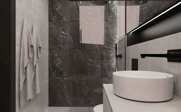 Wnętrze minimalistycznej łazienki z białą umywalką i czarnymi akcentami.