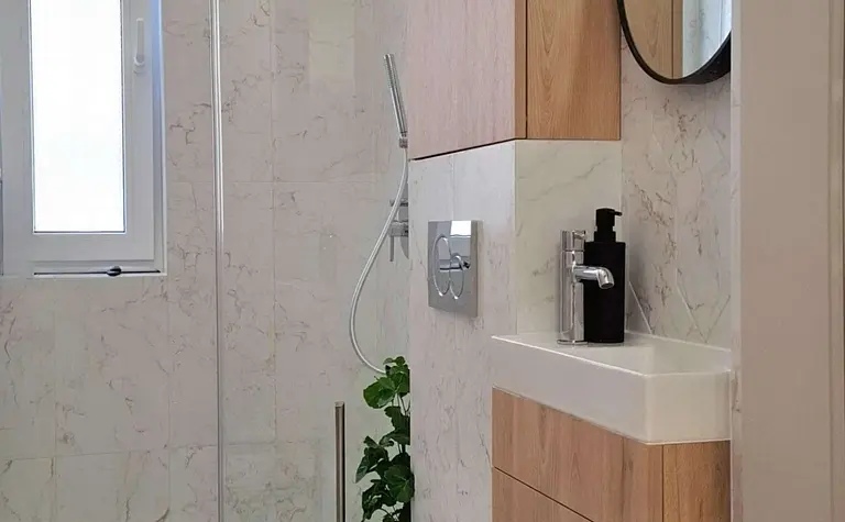 Nowoczesna łazienka z drewnianymi meblami i prysznicem.