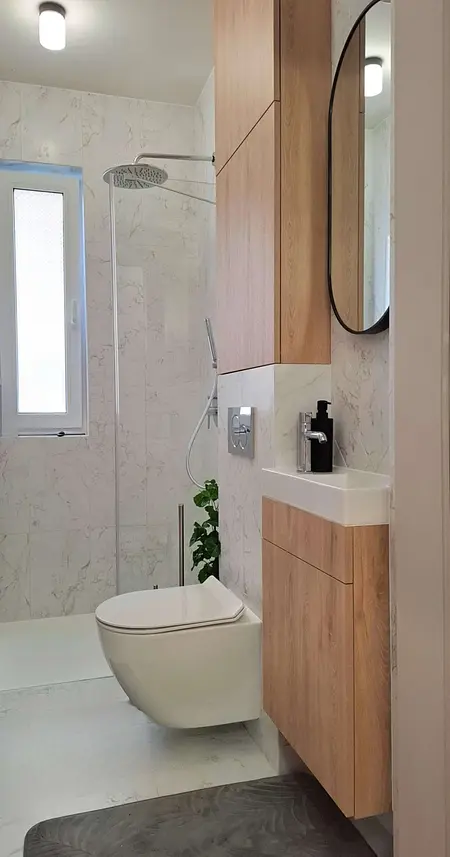 Nowoczesna łazienka z drewnianymi meblami i prysznicem.