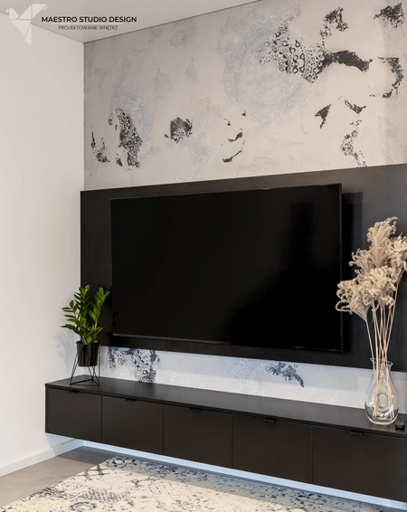 Nowoczesny salon z czarną szafką i dekoracją w stylu glamour, minimalistycznym i współczesnym.