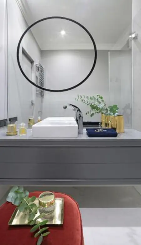 Nowoczesna łazienka z minimalistycznym designem, szarymi detalami i roślinnością.